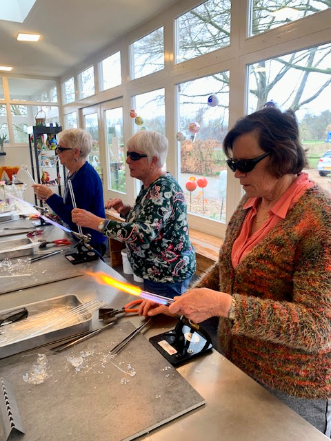 2025 maart – Een leuke ochtend GLASBLAZEN bij Mart Martorell in Laren GLD. Na de koffie met appelgebak was er uitleg over het glasblazen en een demonstratie door Mart. Daarna konden de dames zelf aan de slag. Er werden – na wat mislukte pogingen – o.a. mooie vaasjes gemaakt. Iedereen was actief bezig en enthousiast over het eindresultaat.
