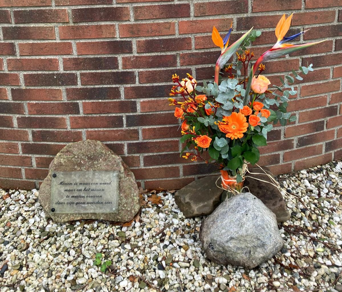 Vrouwen van Nu De Stapel legt oranje bloemen bij Muur tegen geweld